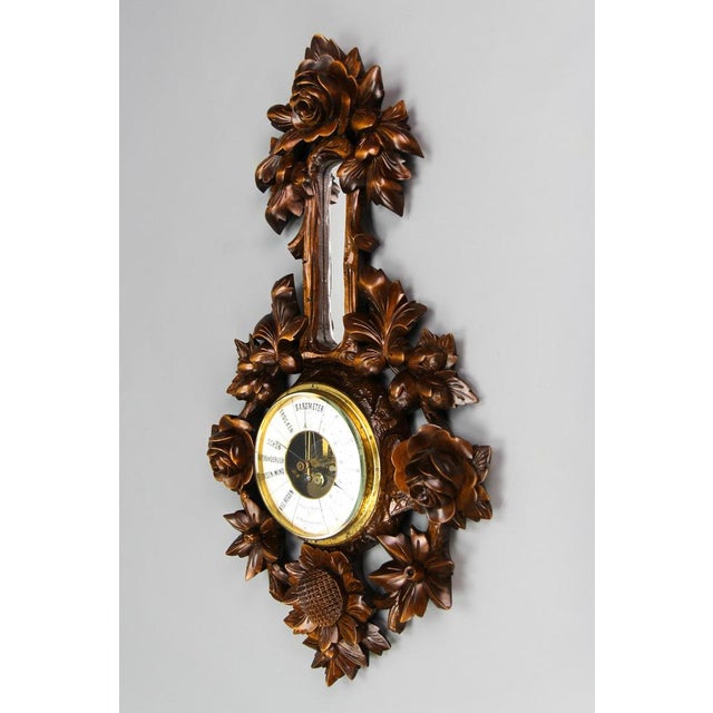 Black Forest style carved walnut barometer, Germany, ca. 1920. An impressive carved walnut barometer with masterfully...