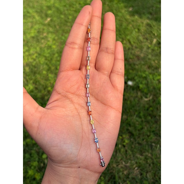 This elegant tennis bracelet featuring a 4.38 carat emerald-cut multi sapphires, set in 14K white gold. Each sapphire...