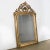 Exquisite 19th Century Louis Philippe Mirror in Gold Gilt, showcasing a captivating ornate cartouche adorned with...