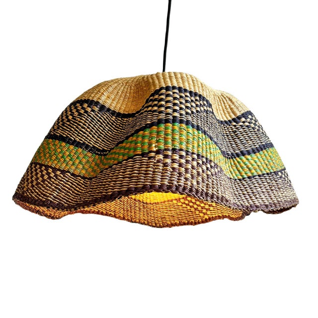 This pendant light began as a traditional Bolga basket from northern Ghana. These baskets were objects of daily use, woven...