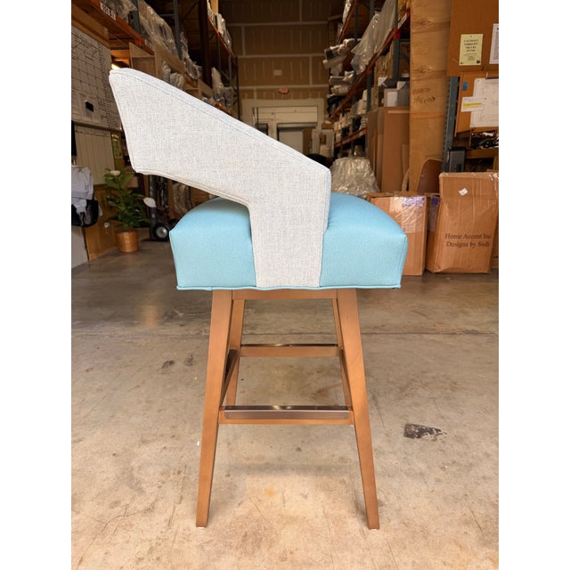 Contemporary counter stool featuring a clean, minimalist silhouette with a natural wood frame and a comfortable leather...