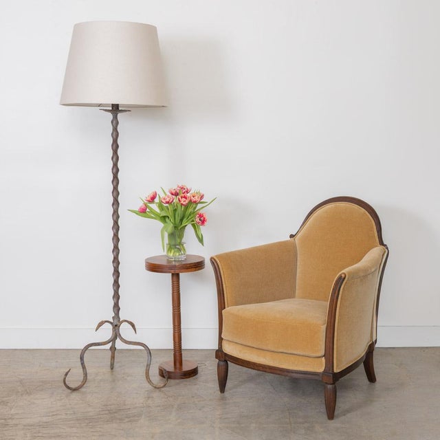Incredible heavy wrought iron floor lamp from France, 1940s. Twisted iron stem with leaf detail on three curved iron legs....