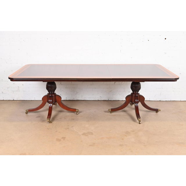 An exceptional Georgian or Regency style double pedestal extension dining table In the manner of Baker Furniture By Guerra...