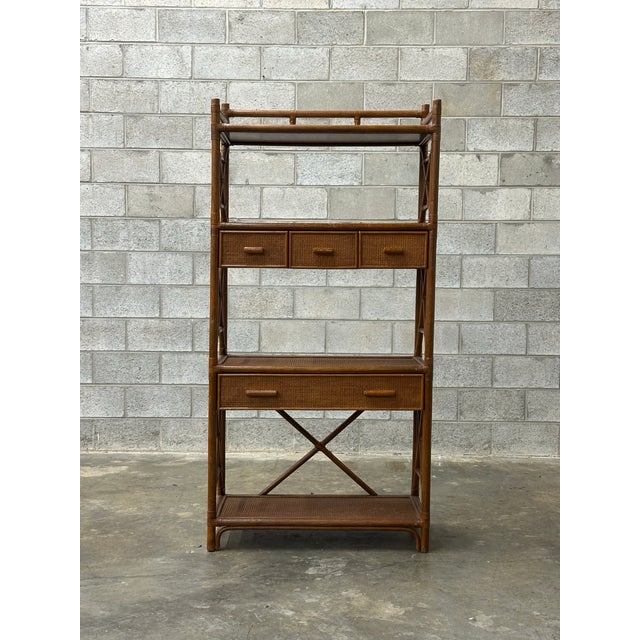 A gorgeous room divider or étagère composed of bamboo, rattan, and cane shelves. Featuring 4 surfaces, a larger drawer and...