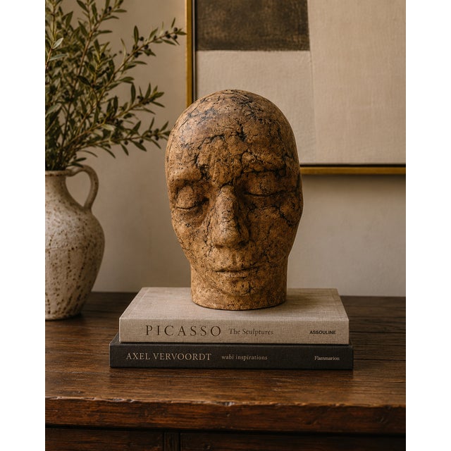 A striking contemporary studio ceramic head sculpture with a serene, introspective expression and richly textured earthen...