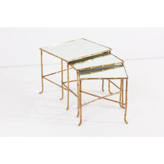 Set of three nesting tables in bamboo shape by maison baguès in france. Made of brass and with mirror tops. The...