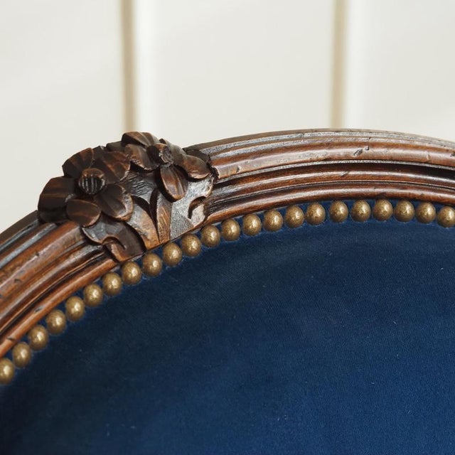 The armchair is crafted in the Louis XV style and belongs to the cabriolet-style armchair type, featuring a curved,...