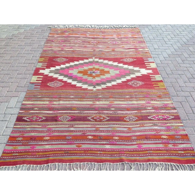 This beautiful, traditional vintage, flatweaved Turkish kilim rug is approximately 60 years old. It is handmade of very...