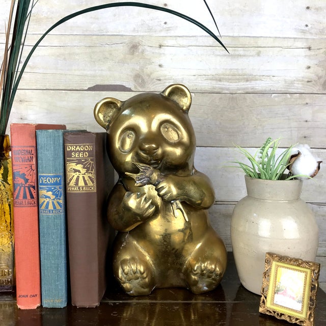 Charming panda statue constructed of warm, shiny brass. Panda is sitting and eating and looks so darn cute. Statue is...