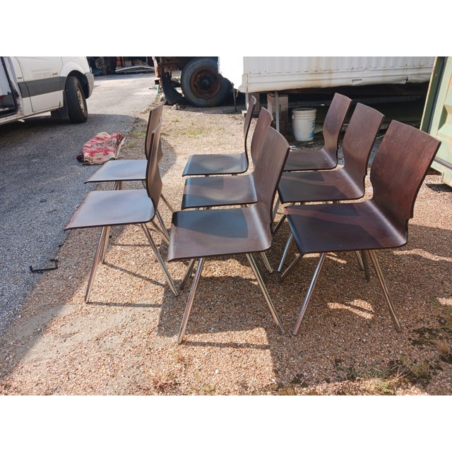 Vintage Mid-Century Modern dining chairs featuring sculptural bentwood seats and backs in a rich dark wood finish. The...