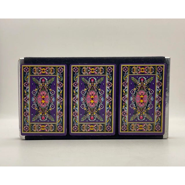 A pack of three decks of vintage playing cards in a violet floral pattern. All decks are complete.