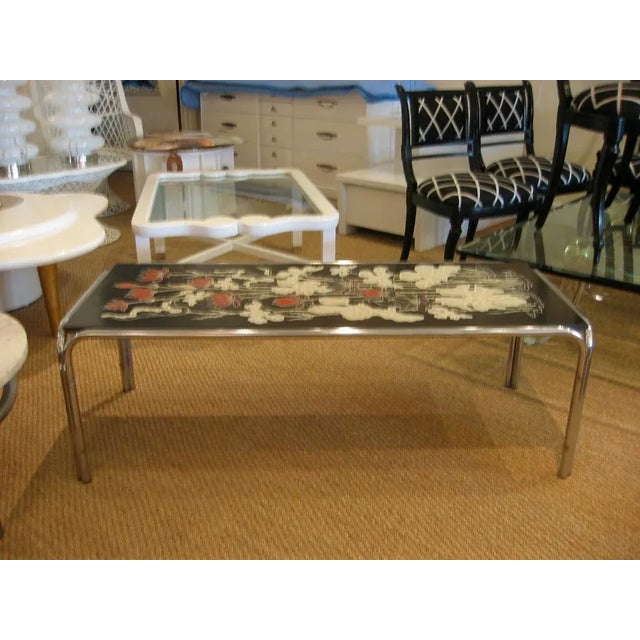 This vintage cocktail table made of tubular chrome base and raised floral design over laminated top is most interesting....