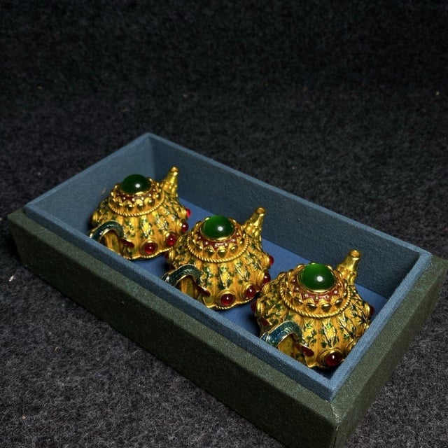 This is an exquisite and unique set of three miniature teapot figurines, presented in a custom-fitted, embroidered fabric...