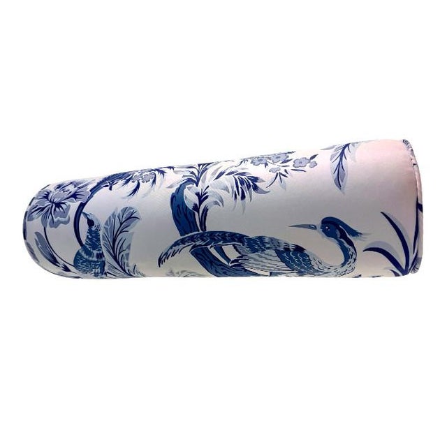 A striking blue and white bolster pillow featuring a classic chinoiserie-inspired bird and botanical motif. The detailed...