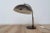 Model 144 desk lamp by H. Busquet for Hala Zeist. The light comes with a brown coated metal shade and base. The frame is...