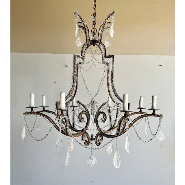 Monumental (10) light beaded wrought iron & rock crystal chandelier. The chandelier is adorned with garlands of beads and...