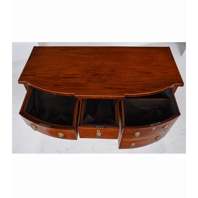 An elegant 19th century English mahogany sideboard distinguished by its graceful serpentine front, rich figured mahogany...