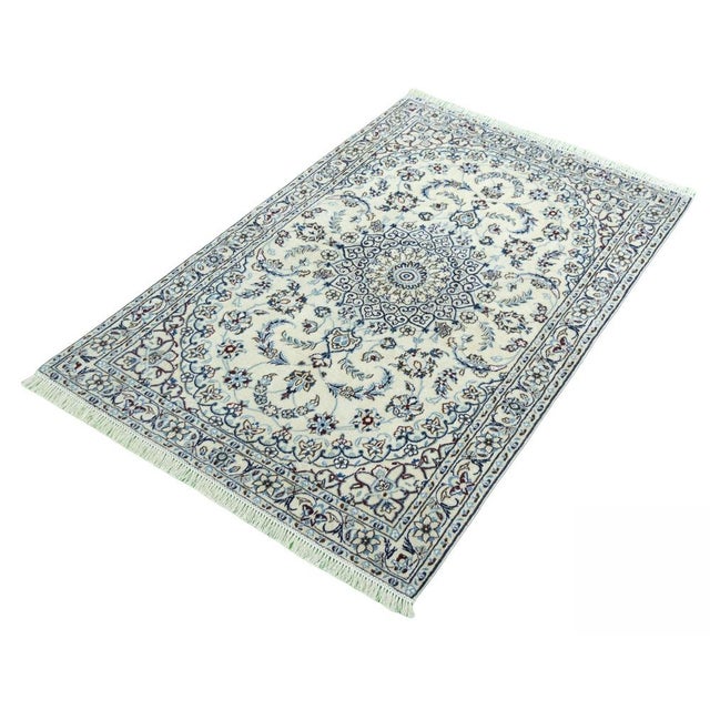 This exquisite hand-knotted rug impresses with its fine knotting and harmonious combination of floral patterns and an...