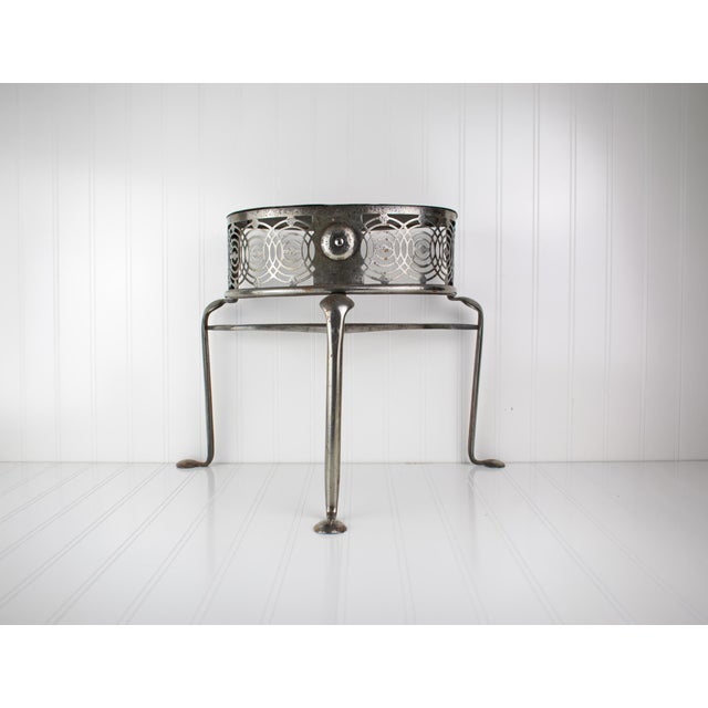 A custom, handmade petite steel side table featuring an industrial silhouette with flared legs and a front skirt detailed...