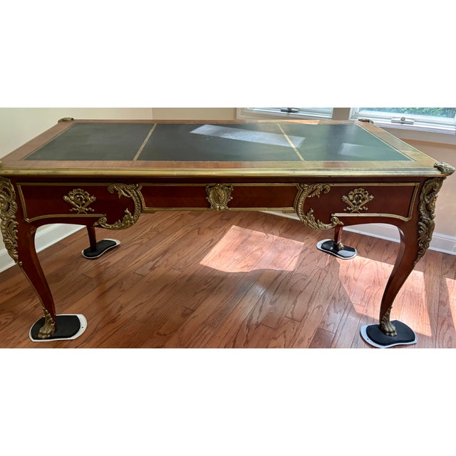 • Three-panel tooled leather top with gilt-tooled border and brass gallery edge/trim • Cast bronze/gilt-bronze hardware on...