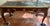• Three-panel tooled leather top with gilt-tooled border and brass gallery edge/trim • Cast bronze/gilt-bronze hardware on...