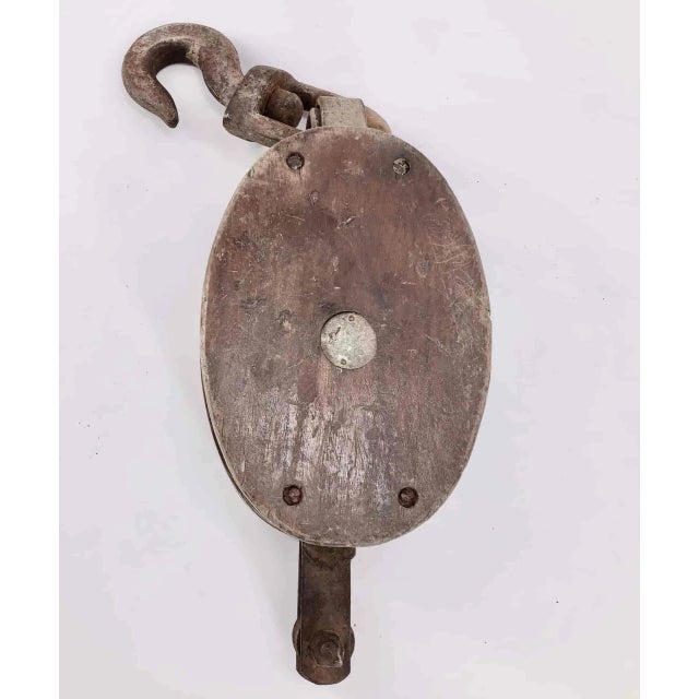 Double pulley in wrought iron and solid wood with inscription "NS Coreto" Old double pulley of boat in its juice with an...