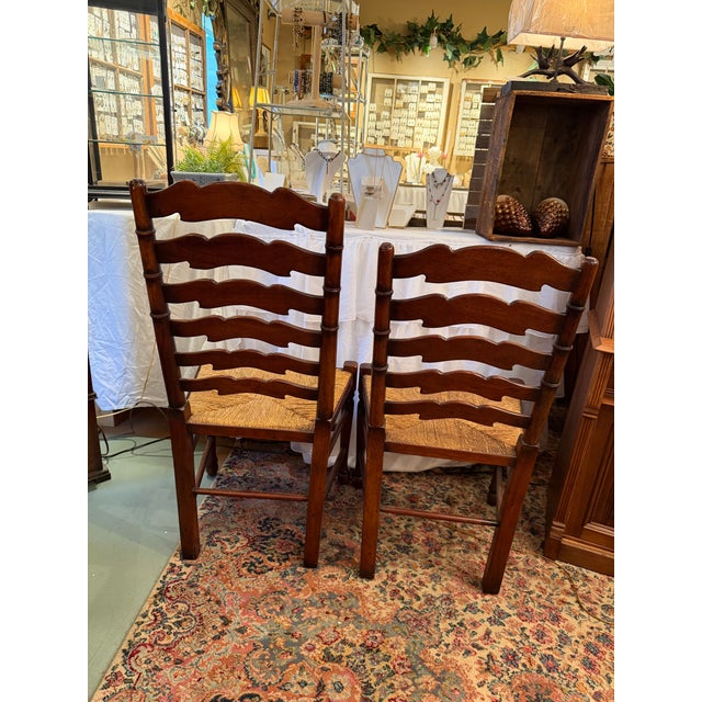 This is a pair of ladder back chairs in a dark wood finish. They are intentionally two different heights: one for the...