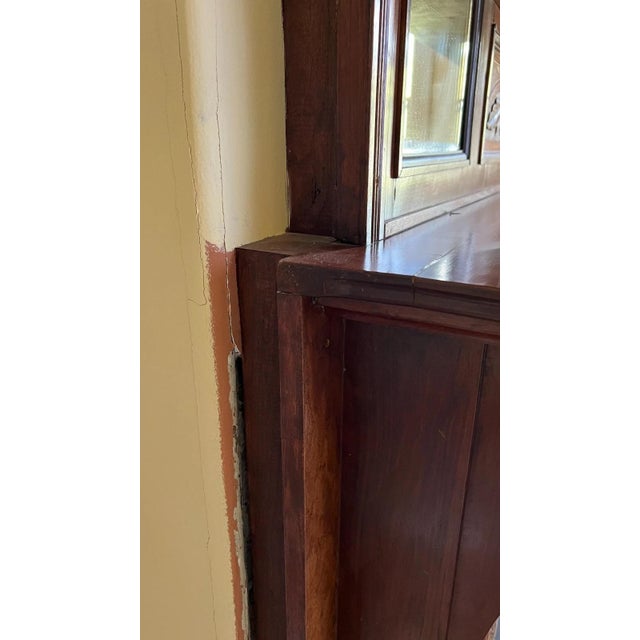 A carved wood Victorian fireplace mantle and surround, featuring a dark wood tone color typical of the 1880s. The set...