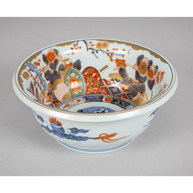 A 10-inch Imari hand-painted porcelain bowl, decorated in the traditional Imari palette of underglaze blue, iron-red, and...