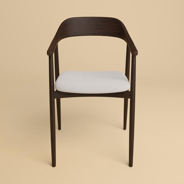 The Mikura is an upholstered oak chair, a seat with a gently curved back and slender lines in Dedar Melange Modern set on...