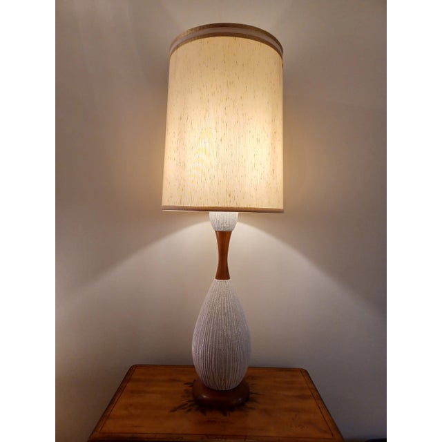 Fabulous ceramic and wood table lamp in beautiful condition. Features a textured body with wood base and neck. It measures...