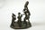 This antique African bronze sculpture depicts a family scene, with a larger father figure surrounded by children,...