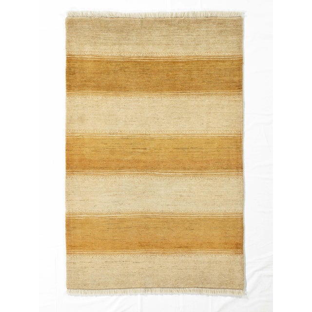 Vintage hand-knotted Persian Gabbeh wool rug with a red field and small stylized tree motifs arranged in a loose grid,...