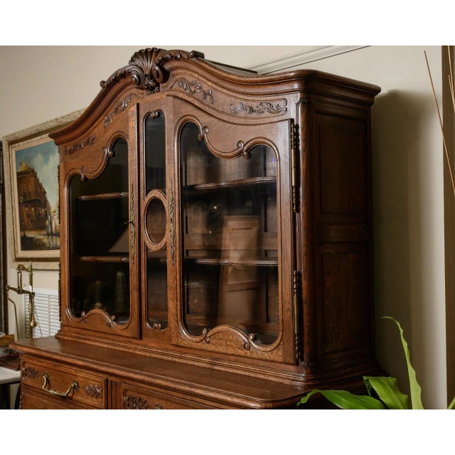 C.1950, French oak buffet with brass hardware, carved panels on the doors, shaped top with raised carving and decorative...