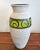 A tall Scheurich Keramik vase with a frothy matt white all over glaze and a glossy apple green band with a matt black wave...