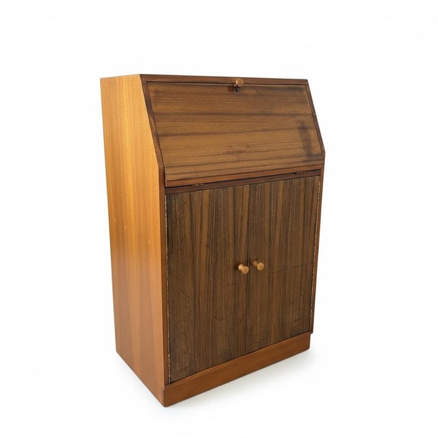 This mid century writing bureau by Morris of Glasgow is a compact vintage desk designed to create an elegant small...