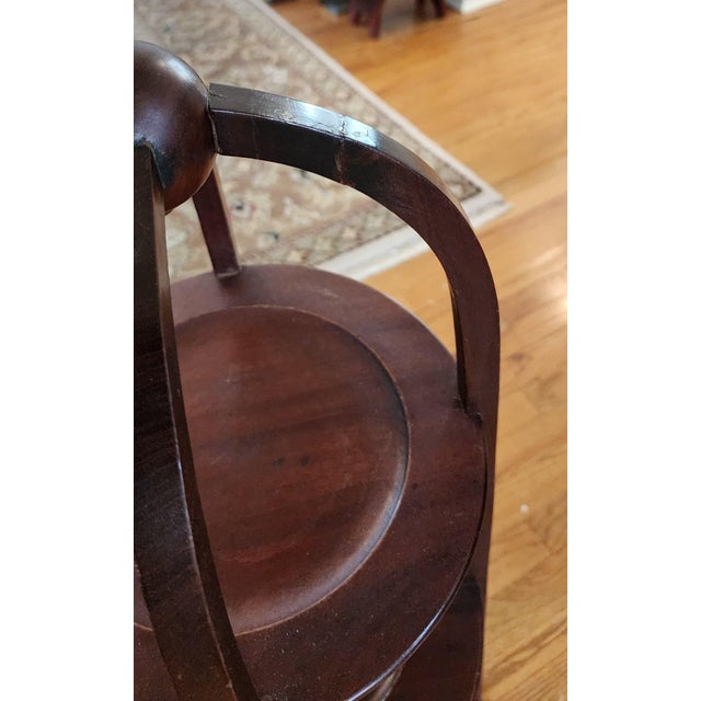 A turn of the 20th century English three-tiered mahogany muffin stand or muffinere traditionally used by hotels and...
