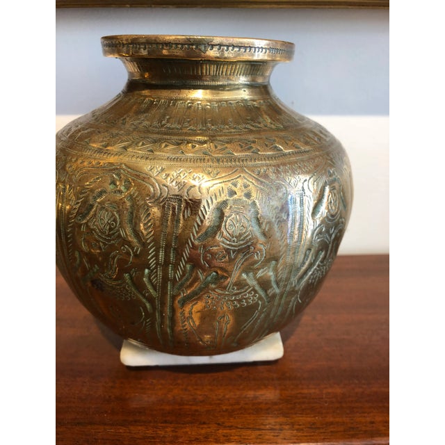 Cast brass vase/container/urn decorated with figures and designs throughout Rounded bottom that balances (could have been...