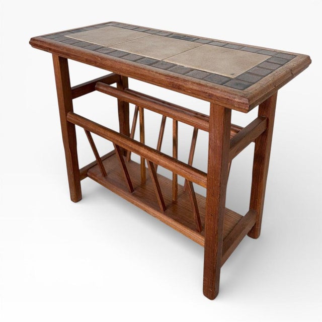 A charming mid-century teak magazine rack featuring a decorative tiled top, combining practicality with classic period...
