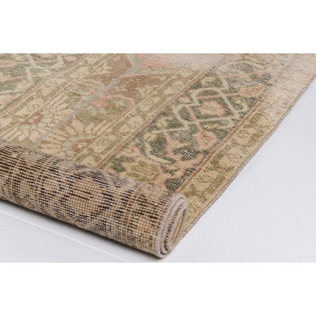 This is a vintage Turkish Oushak rug from the Mid 20th Century. The piece was hand-knotted.