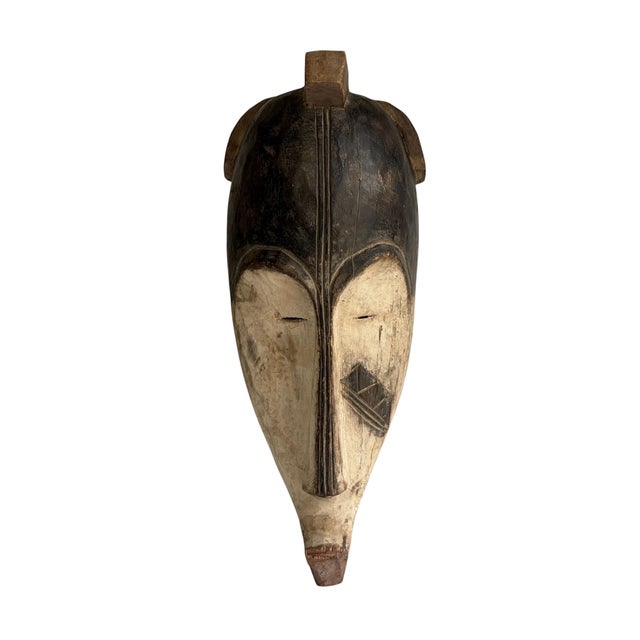 Superb vintage Fang mask carved from a single piece of heavy wood, featuring an elongated heart-shaped face rendered in...