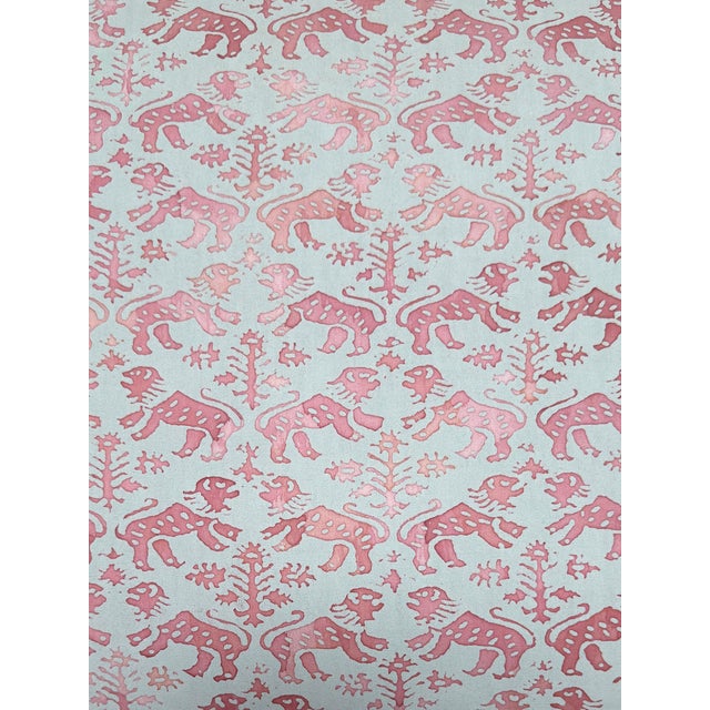 One of four pattered pink and grey fortuny pillows.