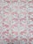 One of four pattered pink and grey fortuny pillows.