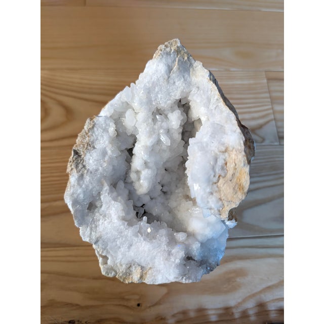 This large quartz crystal geode specimen features an open cavity filled with sparkling white and translucent crystal...