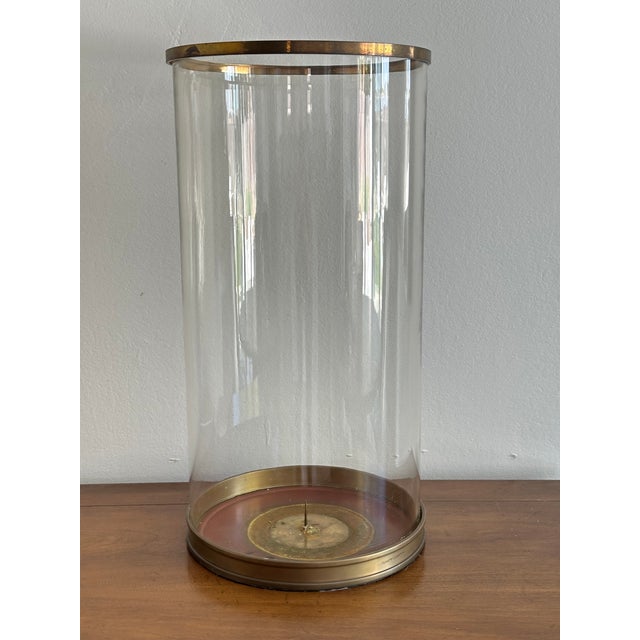 Oversized Ralph Lauren glass hurricane lantern featuring a substantial cylindrical glass shade with warm brass trim at the...