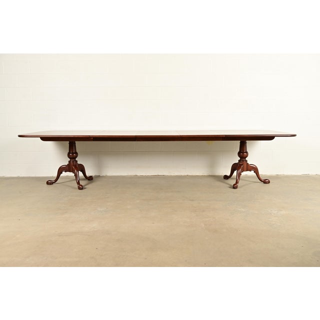 A gorgeous Georgian, Regency, or Queen Anne style solid carved cherry wood double pedestal extension dining table By...