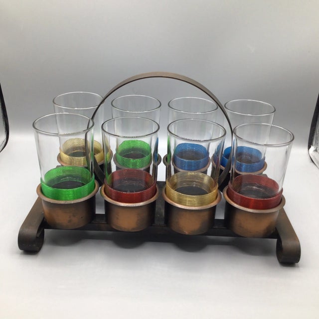 Great 8 glass caddy with 8 plastic wrapped highball glasses. Caddy is rolled steel with a bronze finish. There’s 4 sets of...