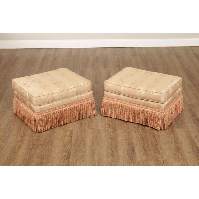High Quality American Made Vintage Pair of Upholstered Ottomans with Fringed Skirt and Rolling Casters