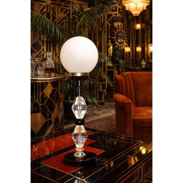 A striking mid-century table lamp dating to circa 1950, combining a sculptural stacked faceted-glass column with an...