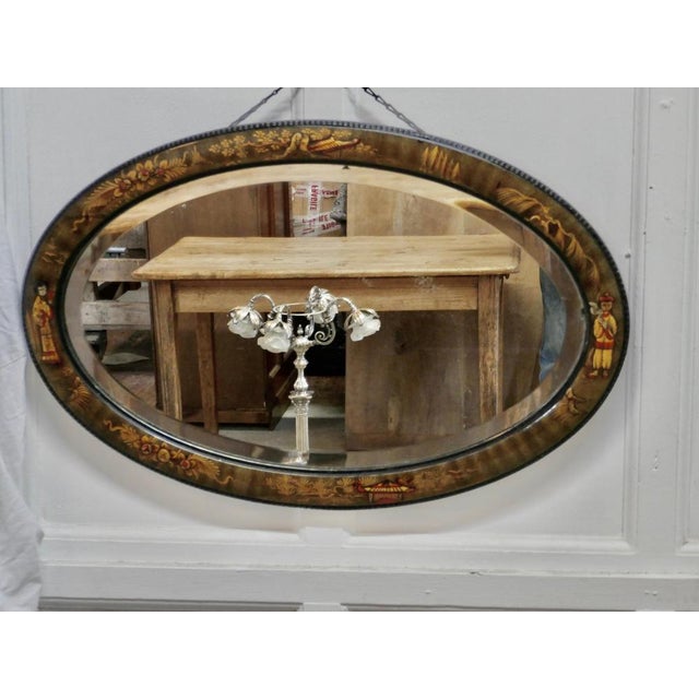 Black lacquer chinoiserie oval wall mirror This oval shaped mirror has delightful embossed chinoiserie decoration on a...